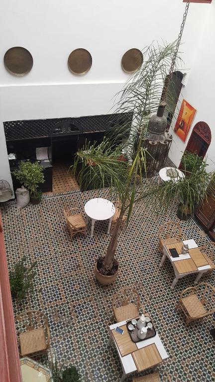 un salon avec une table, des chaises et des plantes dans l'établissement Dar Iman, à Fès