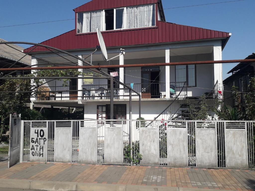 a white house with a red roof and a fence at kobuleti bagrationi 40 in Kobuleti