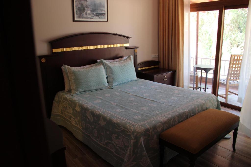 a bedroom with a bed with a blue comforter at Adrasan La Casita Hotel in Adrasan