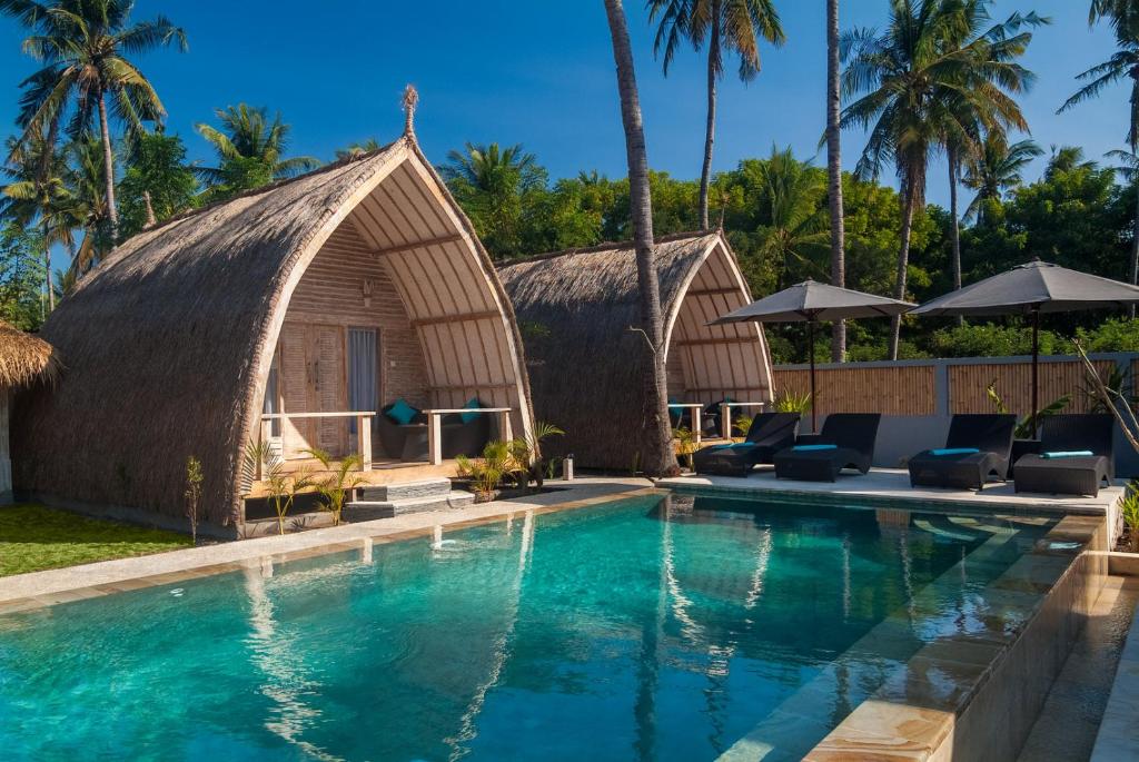 a resort with a swimming pool and a thatched building at Gili Meno Escape - Adults Only in Gili Meno