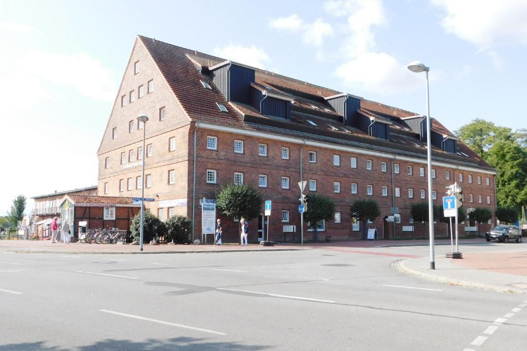 ein großes rotes Backsteingebäude in einer Stadtstraße in der Unterkunft Ferienwohnung Kietzspeicher in Waren (Müritz)