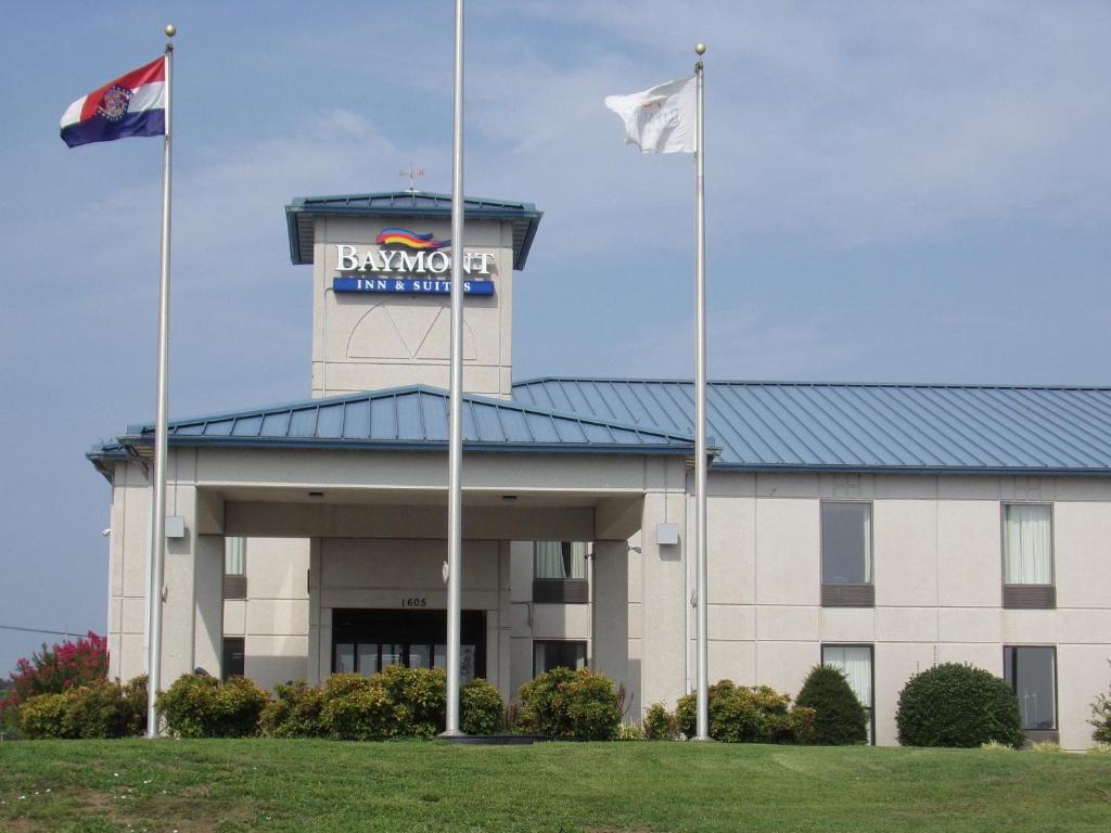 a building with two flags in front of it at Baymont by Wyndham West Plains in West Plains