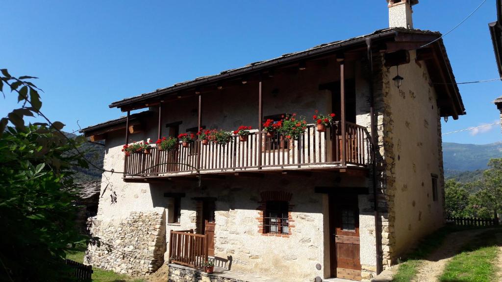 an old building with flower boxes on the balcony at La Baita nel Bosco in Brossasco