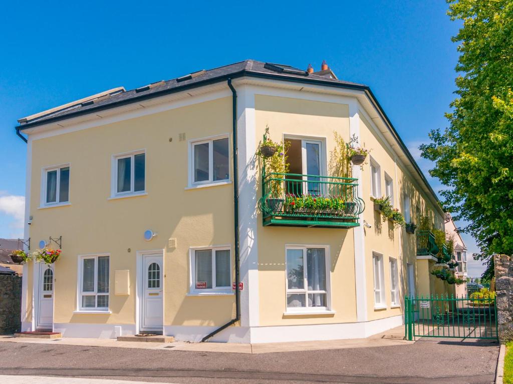 a large yellow building with a balcony at Waterfront Self Catering Houses in Carrick on Shannon