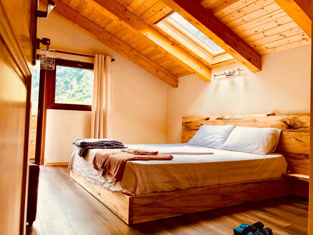a bedroom with a bed in a room with a window at Bujtina Polia in Theth