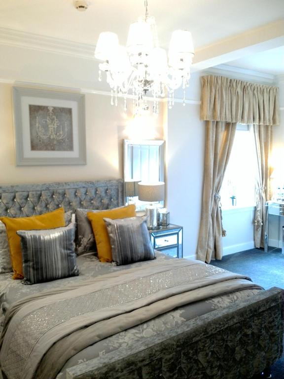sypialnia z dużym łóżkiem i żyrandolem w obiekcie Aaran Lodge Guest House w Edynburgu