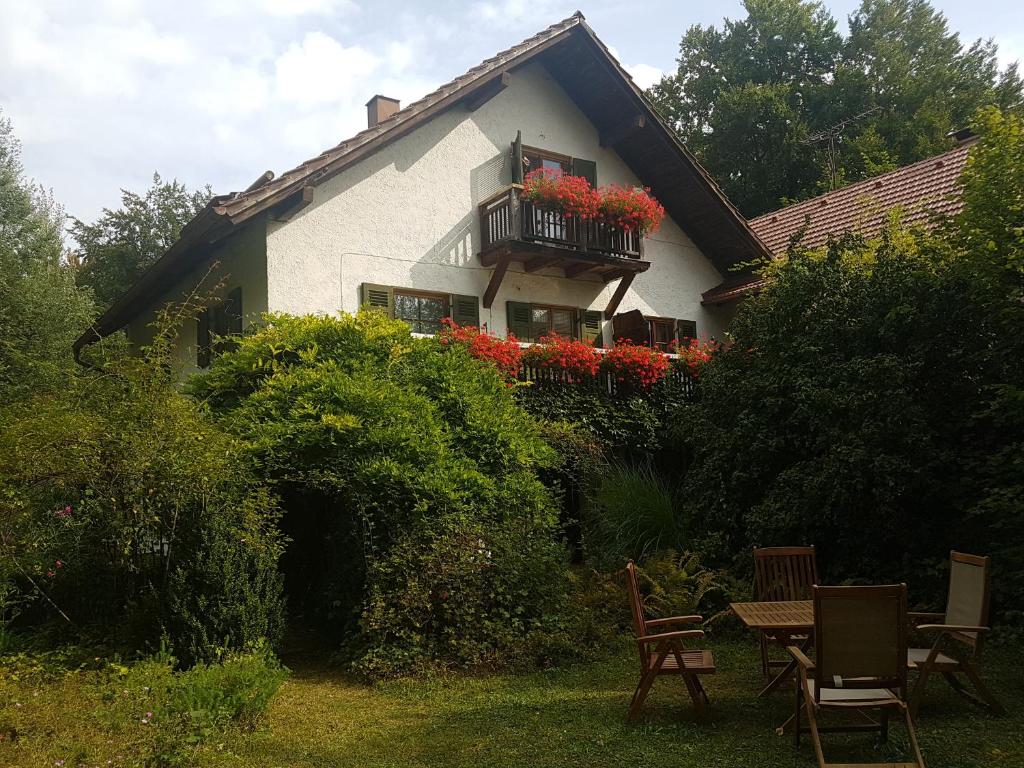 une maison avec un balcon orné de fleurs rouges. dans l'établissement Martina's place, à Rottenbuch