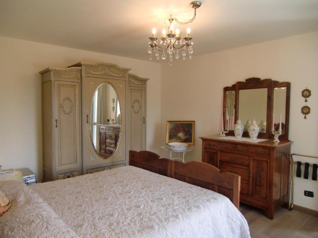 sypialnia z łóżkiem, komodą i lustrem w obiekcie B&B LA VIGNA DI TINA w mieście Costigliole dʼAsti