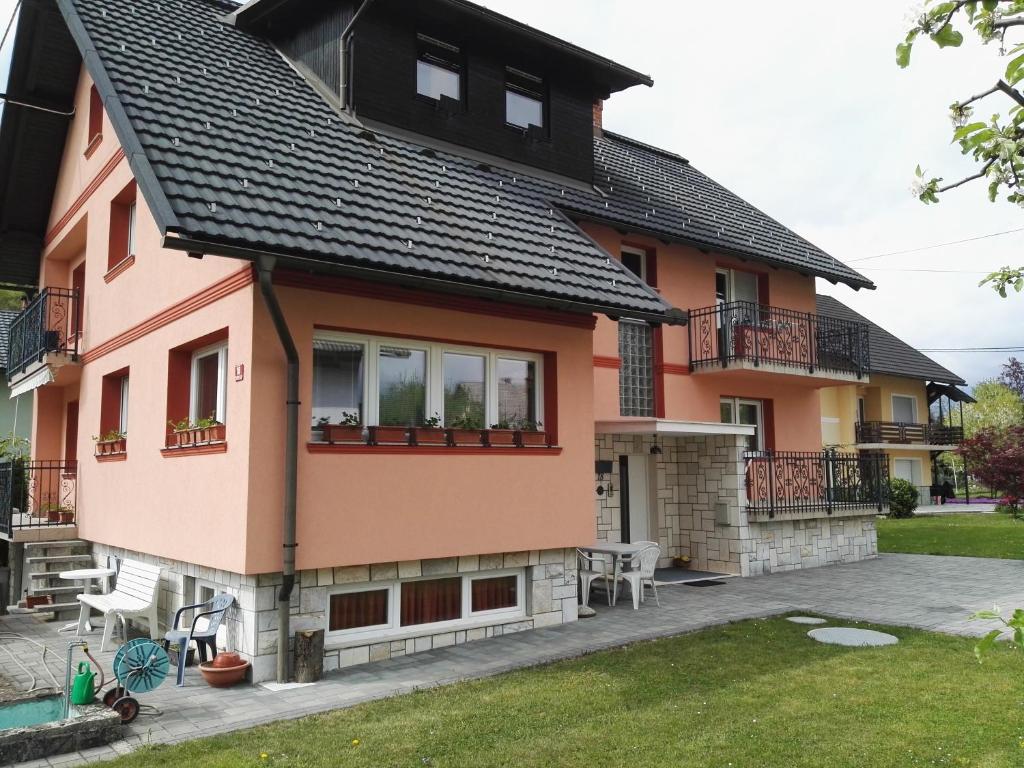 una casa rosa con techo negro en Apartments Silič en Bled