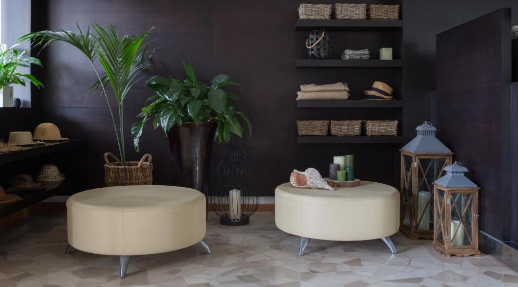 un soggiorno con due sedie e una pianta di Harvey Suites Hotel & Residence a Lido di Jesolo