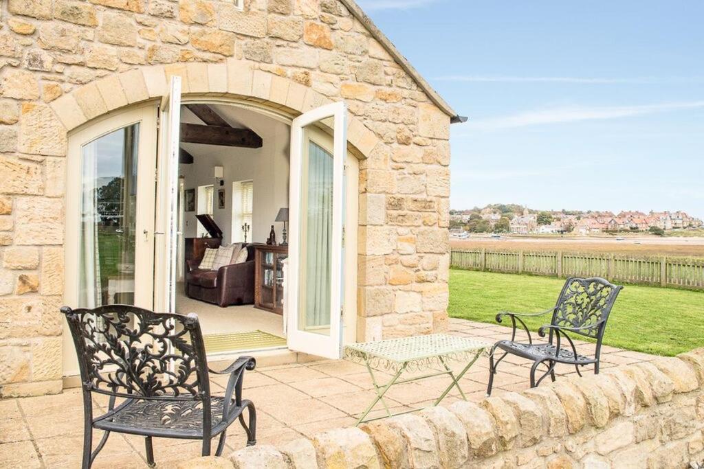 two chairs and a table on a patio at Beach View, Waterside Cottages in Alnmouth
