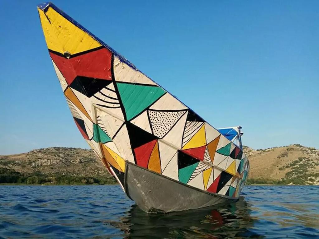 a colorful sail boat floating in the water at Holiday home Haustor with Skadar lake view in Podgorica