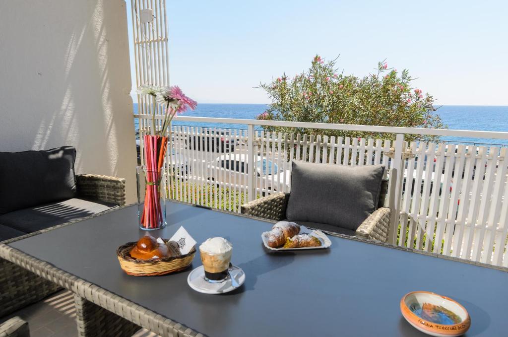 uma mesa azul com uma tigela de comida numa varanda em Marina D'Agrò Residence em Santa Teresa di Riva