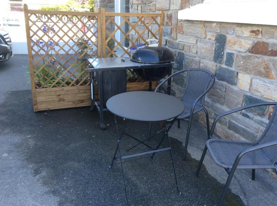 a table and chairs next to a grill and a table and chairs at Cosy&#39;s Sable in Larmor-Plage
