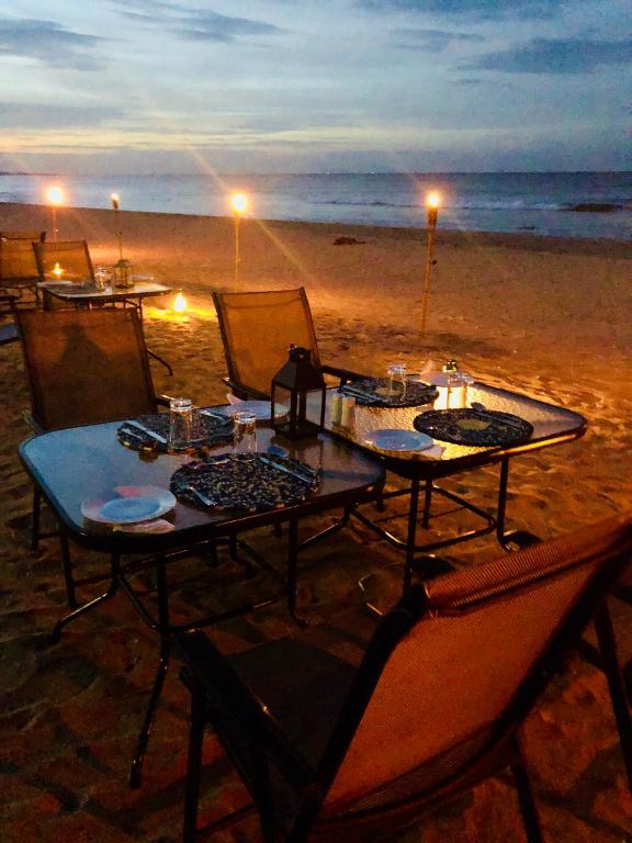 a table and chairs on the beach at night at C Beyond Nilaveli in Nilaveli