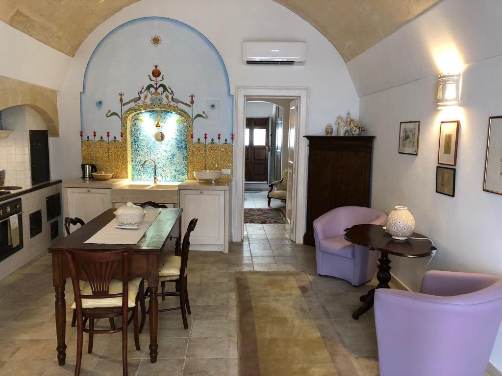 una cucina e una sala da pranzo con tavolo e sedie di “Il Mosaico” Suite Apartment - Grottaglie a Grottaglie