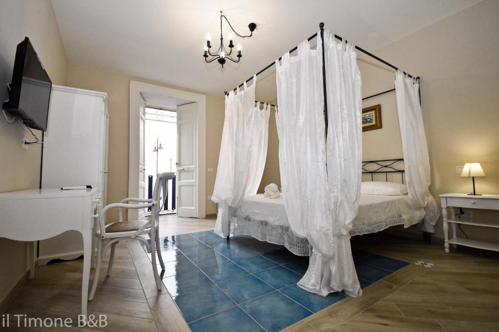 - une chambre avec un lit à baldaquin et des rideaux blancs dans l'établissement il Timone B&B, à Castellammare di Stabia