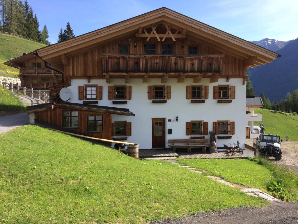 a house with a wooden roof on a hill at Berghütte Schöpf in Umhausen