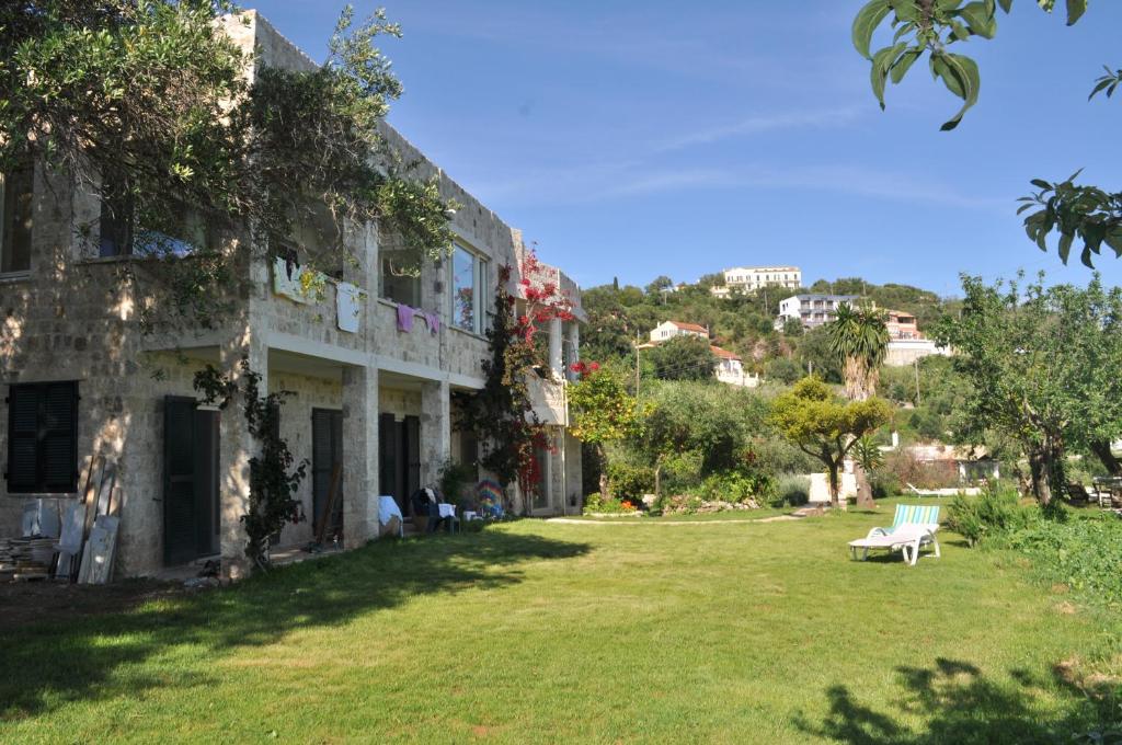 un edificio con un cortile con una panchina di fronte di Lemoni Apartments a Pelekas