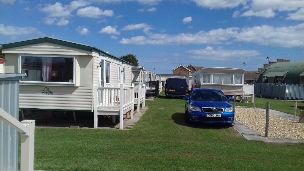 a small car parked in front of some mobile homes at Silver beach in Ingoldmells