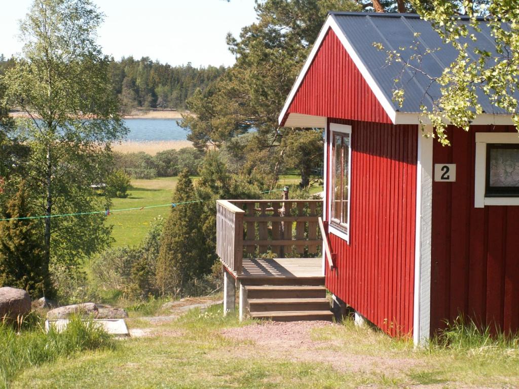 a red building with a ramp leading to a deck at Söderö Stugby in Finström