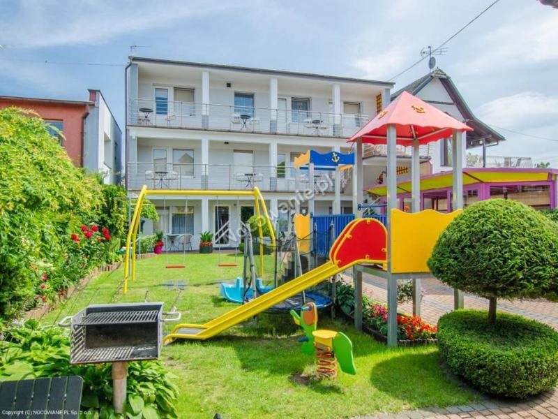 um parque infantil em frente a um grande edifício em Fonica em Leba
