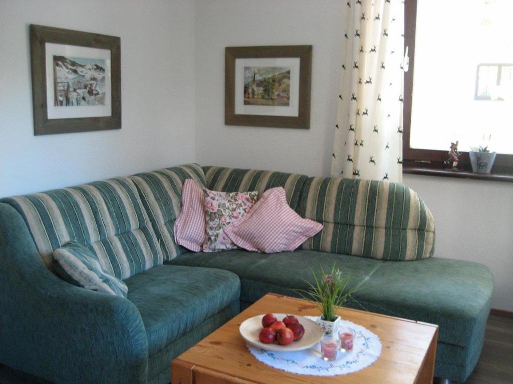 sala de estar con sofá verde y mesa en Ferienwohnung Hanni en Wagrain