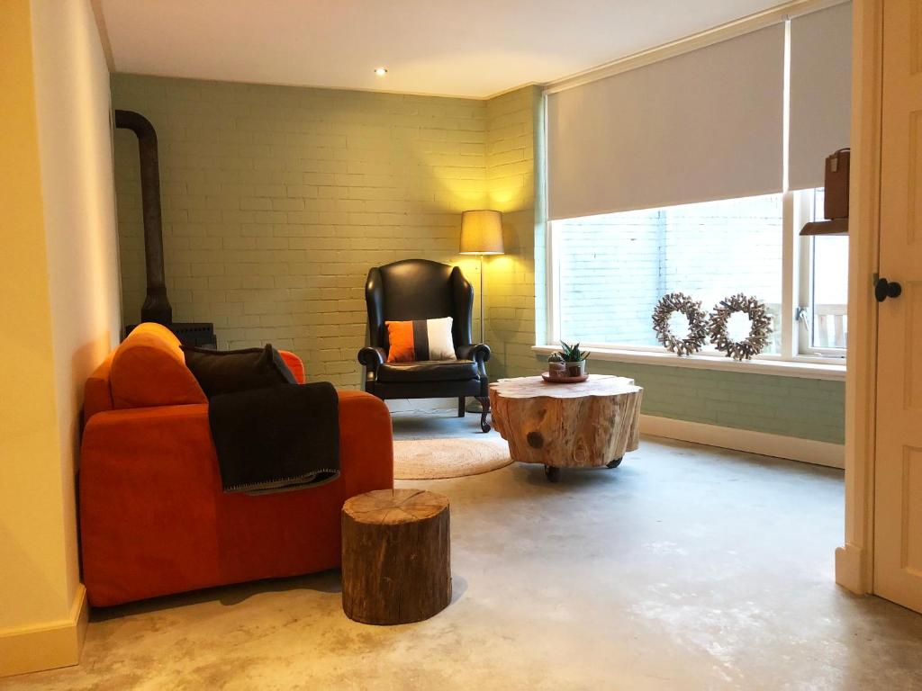 a living room with a orange couch and a table at The Old Garage in Tilburg