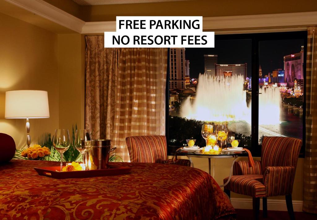 a hotel room with a table and a sign free parking no resort fees at Jockey Club Suites in Las Vegas