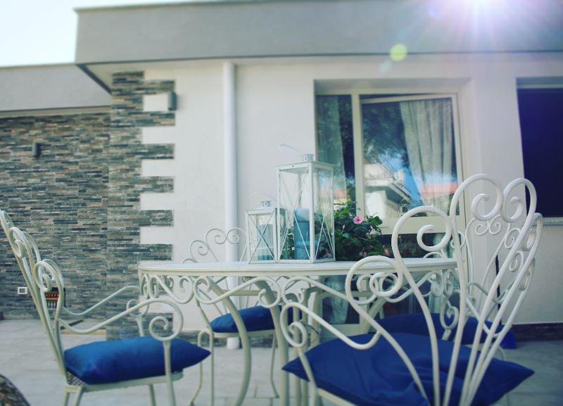 蒙德羅的住宿－Il Sole di Mondello，庭院里的白色桌椅