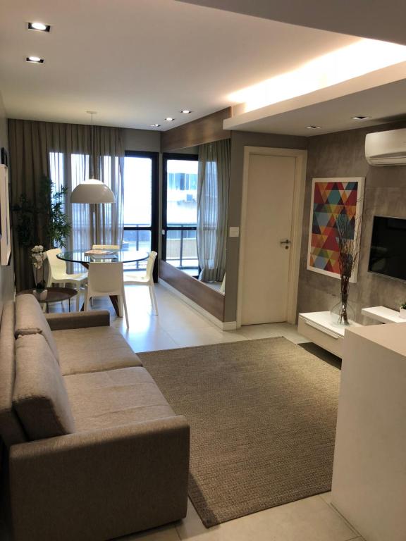 a living room with a couch and a dining room at Flat Prudente de Morais in Rio de Janeiro