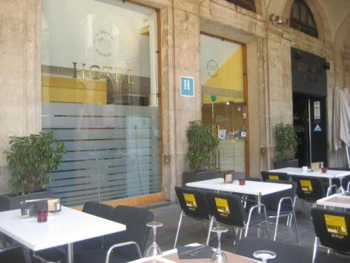 een groep tafels en stoelen voor een gebouw bij Roma Reial in Barcelona