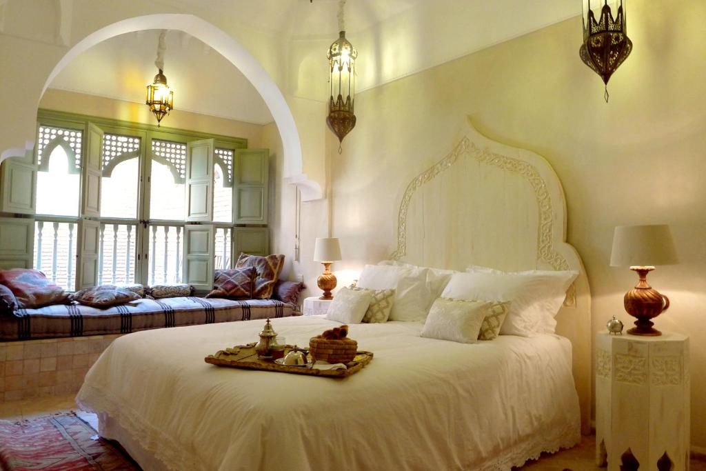 - une chambre avec un grand lit blanc et un canapé dans l'établissement Riad Palacio De Las Especias, à Marrakech
