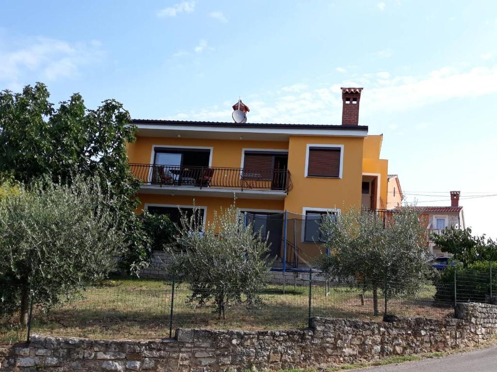 een geel huis met een kat op het dak bij Karlo in Poreč