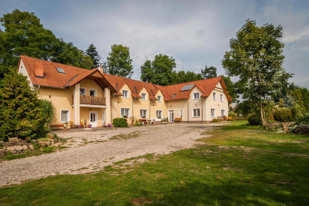 une grande maison avec une route en gravier devant elle dans l'établissement Penzion Agáta, à Žehrov