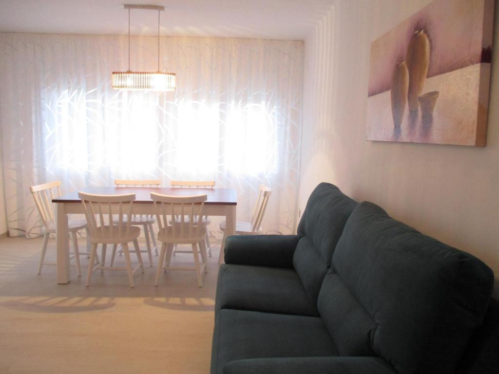 ein Wohnzimmer mit einem Sofa und einem Esstisch in der Unterkunft Apartamento recién reformado y climatizado en ubicación inmejorable. in Peñíscola
