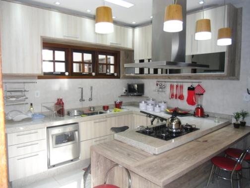 a kitchen with white cabinets and a counter top at Casa de Férias Mãe Maria in Aparecida