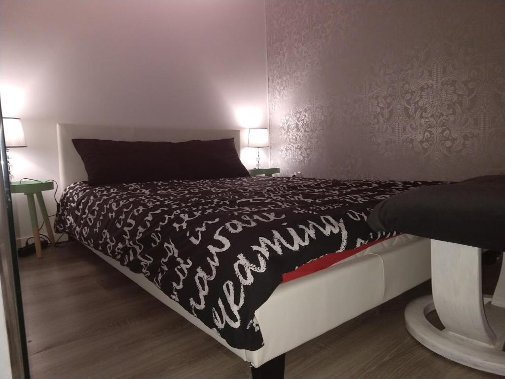 a bedroom with a bed with a black and white comforter at My Secret Place. in Zielona Góra