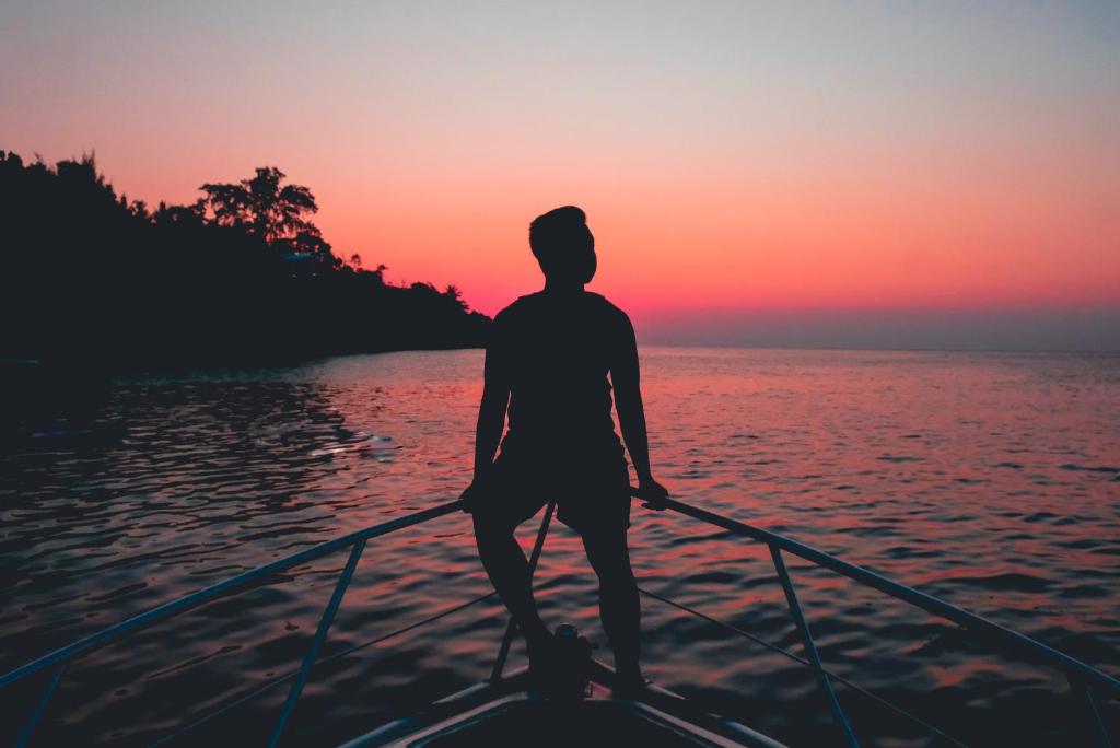 a man is rowing a boat on the water at sunset at Fisher Inn Resort & Marina in Islamorada