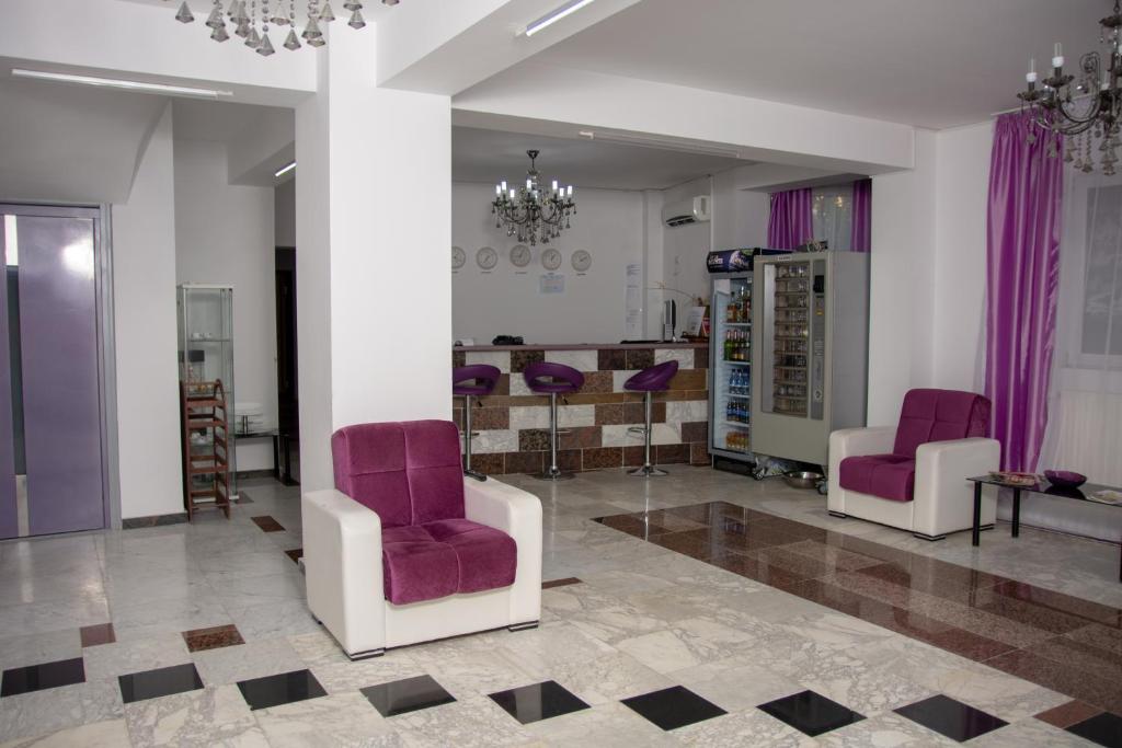 sala de estar con 2 sillas y mesa en Iris Boutique en Otopeni