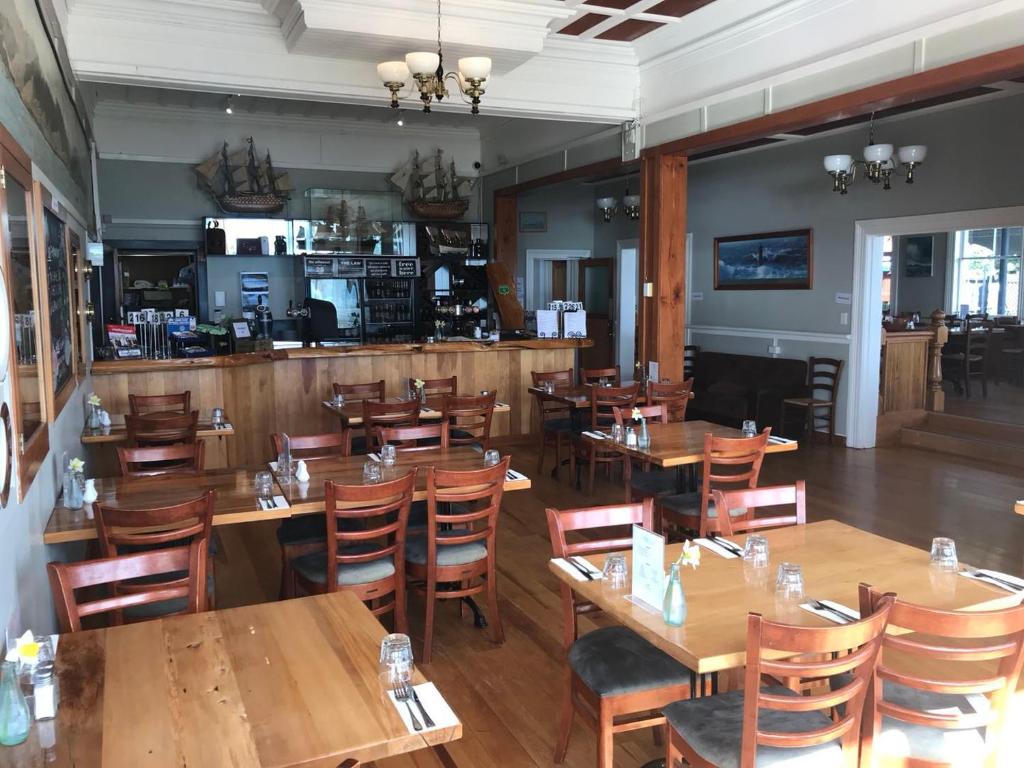 a dining room with wooden tables and chairs at The Pier Hotel in Kaikoura