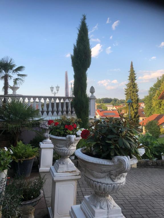 una fila de jarrones blancos llenos de flores y plantas en La Suite en Baden-Baden