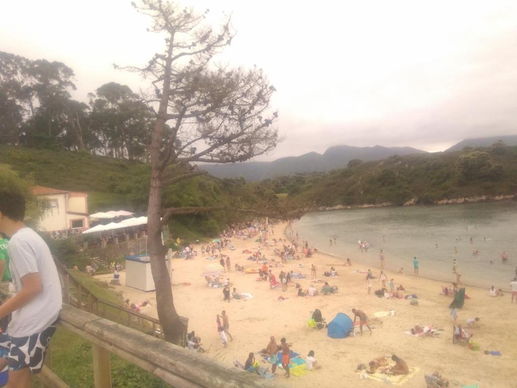 a group of people on a beach near the water at Villa maria in poo de Llanes