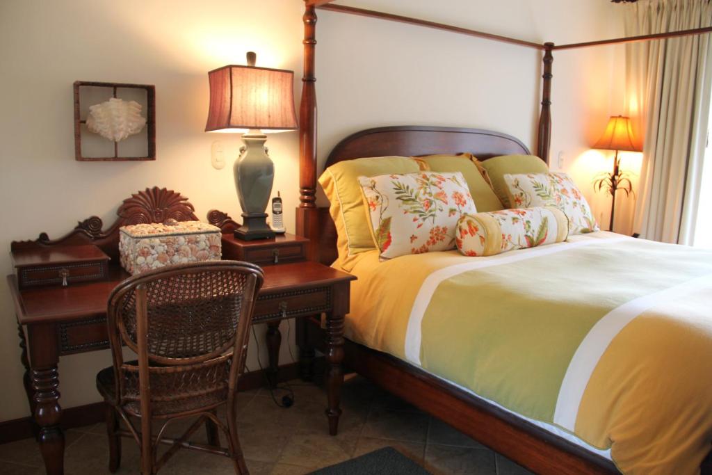 1 dormitorio con 1 cama y escritorio con lámpara en Los Suenos Resort Veranda 2B by Stay in CR, en Herradura