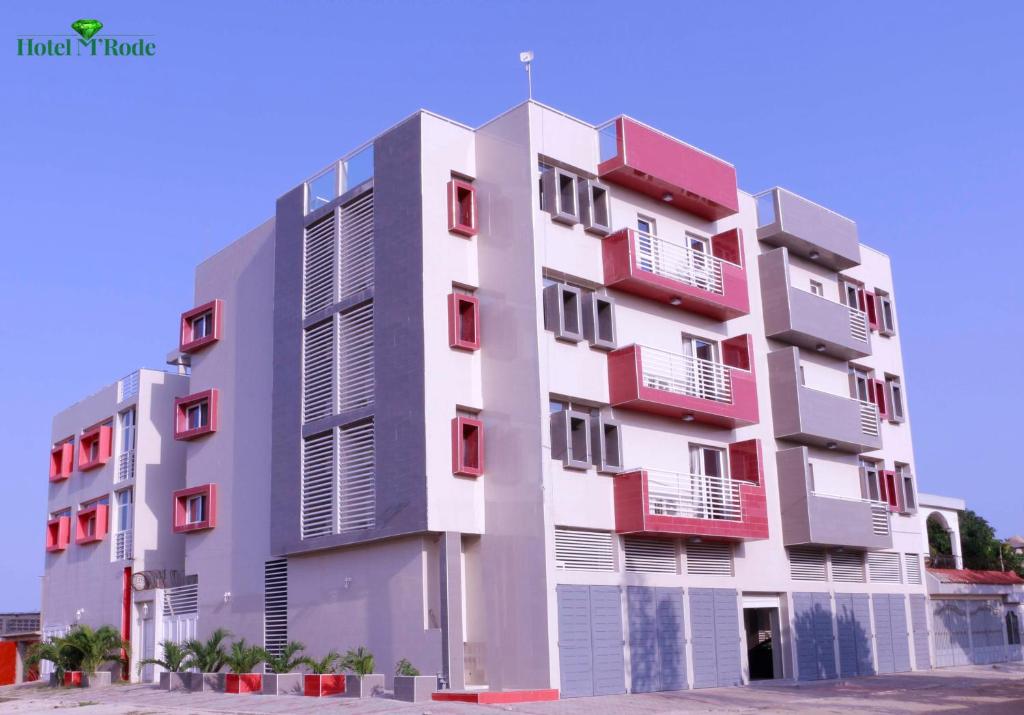a building with red balconies on the side of it at Appart M'Rode Baguida in Lomé