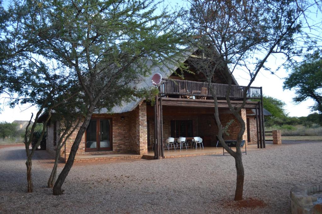 a small house with a balcony and a deck at Makhato 84 Bush Lodge in Bela-Bela