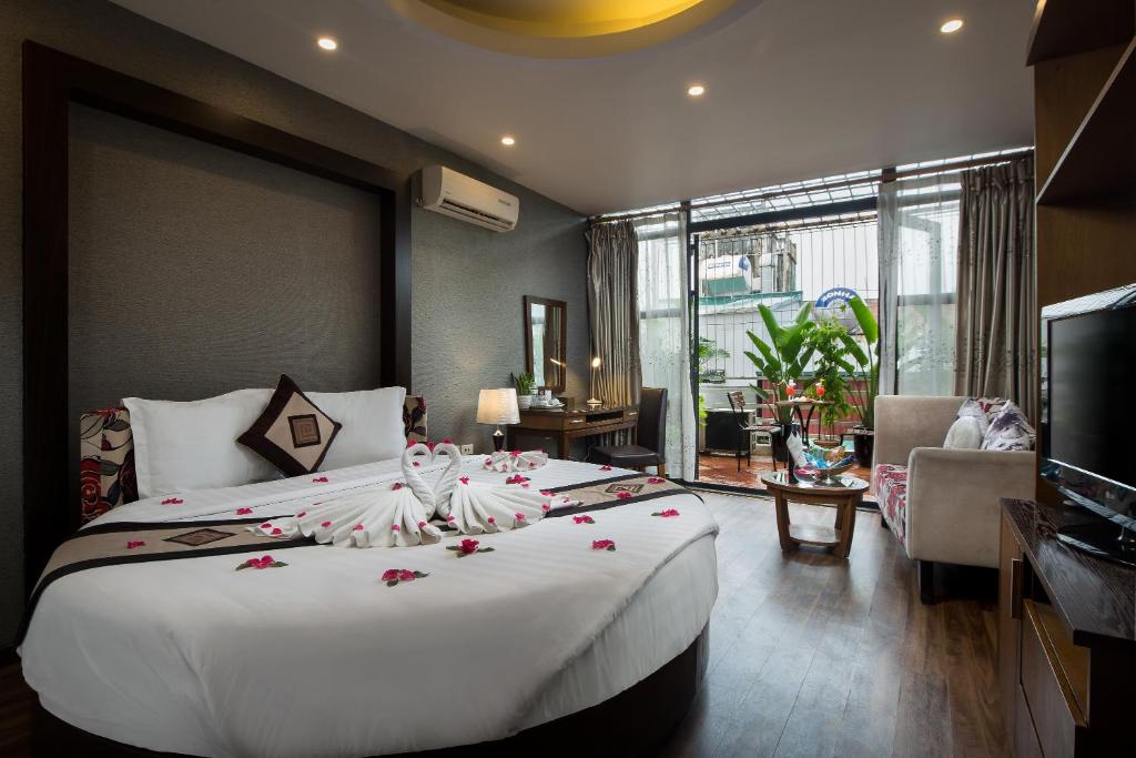 a bedroom with a large white bed with flowers on it at Splendid Star Grand Hotel and Spa in Hanoi