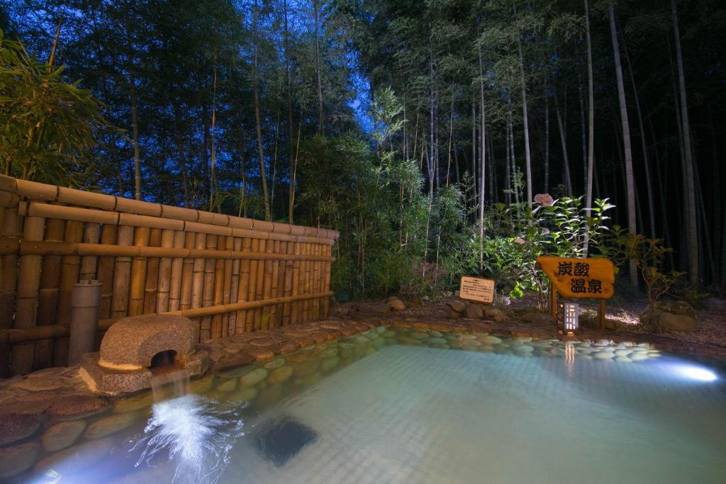 una piscina en un patio con una valla y árboles en Koderaso en Himeji