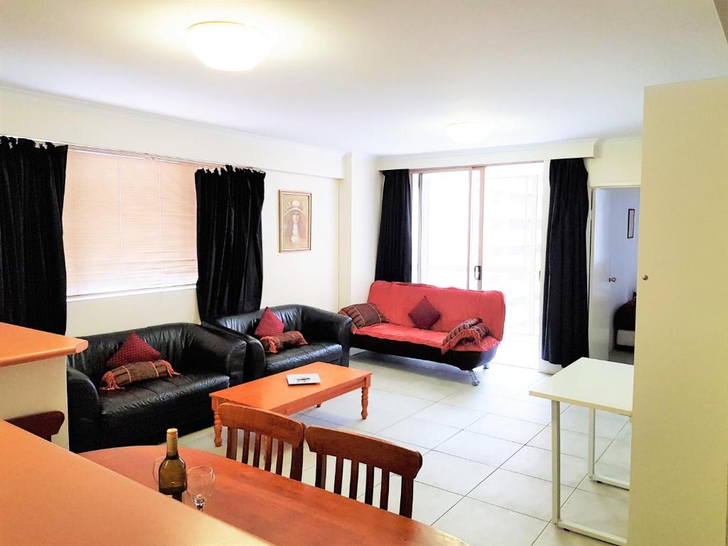 a living room with couches and a table at Accommodation Sydney - Pitt Street in Sydney