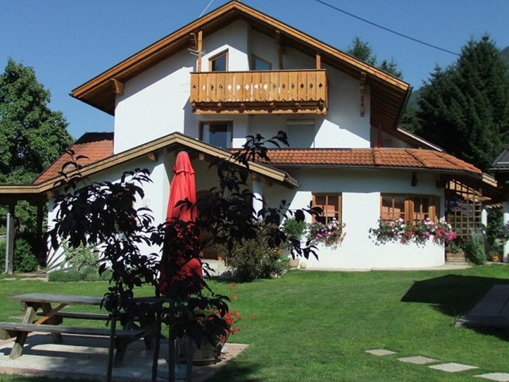 a house with a bench and an umbrella in front of it at Apart Auszeit in Arzl im Pitztal